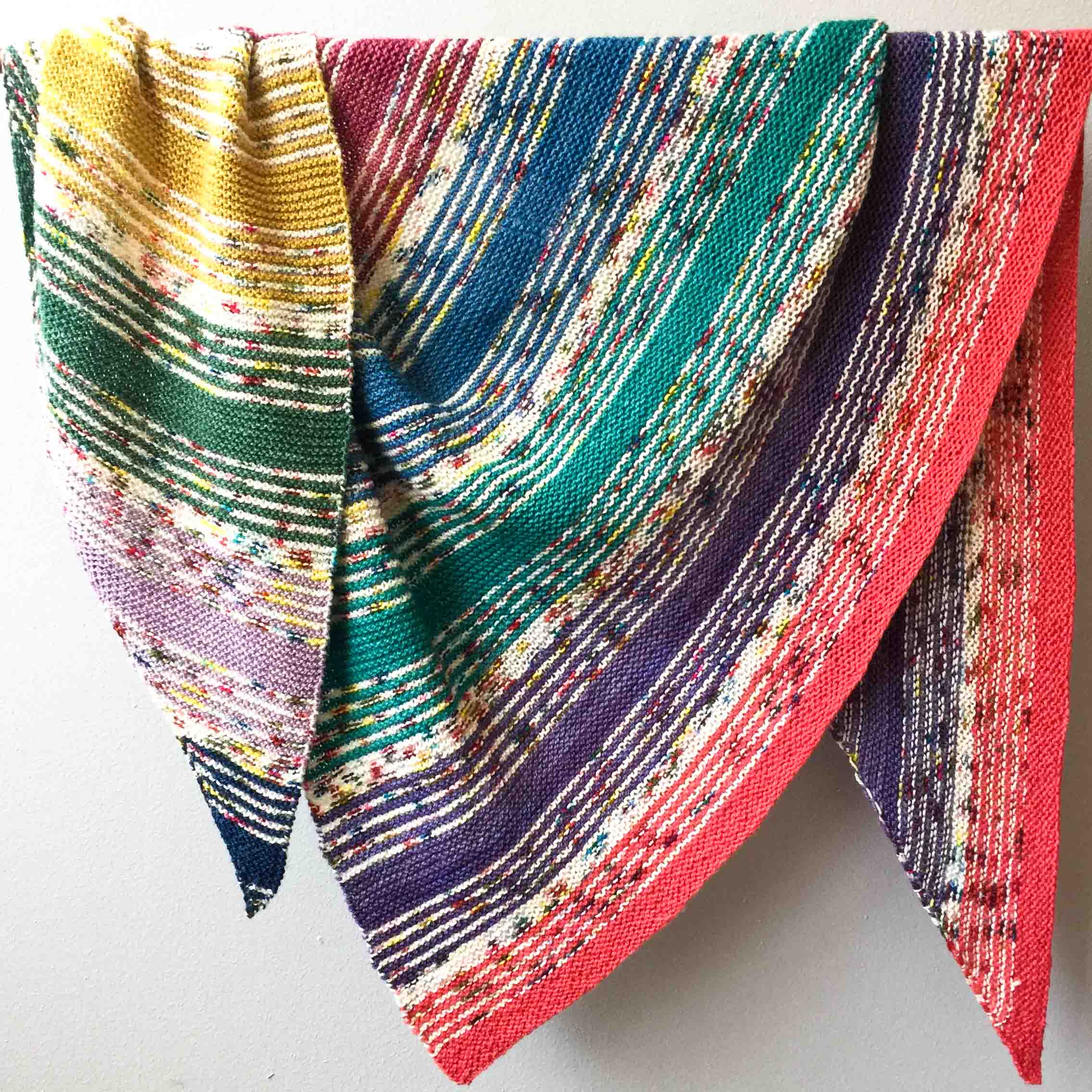 Rainbow striped hand knit triangle shawl in Cowgirlblues Merino Twist yarn