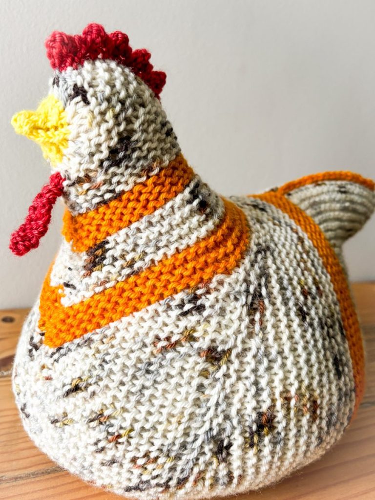 A knitted chicken on a wooden table